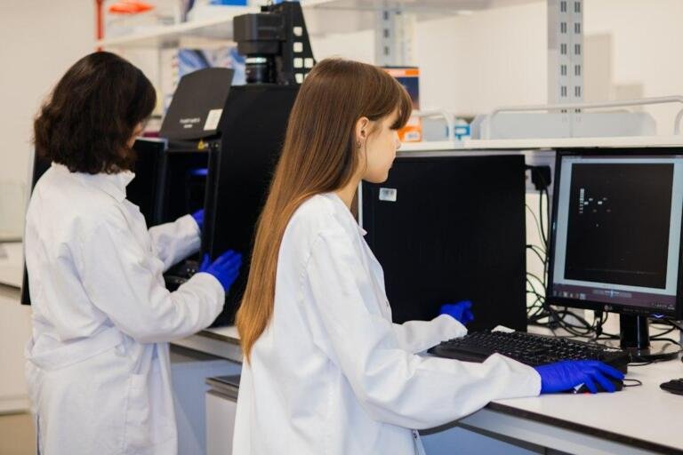 Two researchers working on computers in a laboratory, illustrative stock photograph for independent AI safety reviews